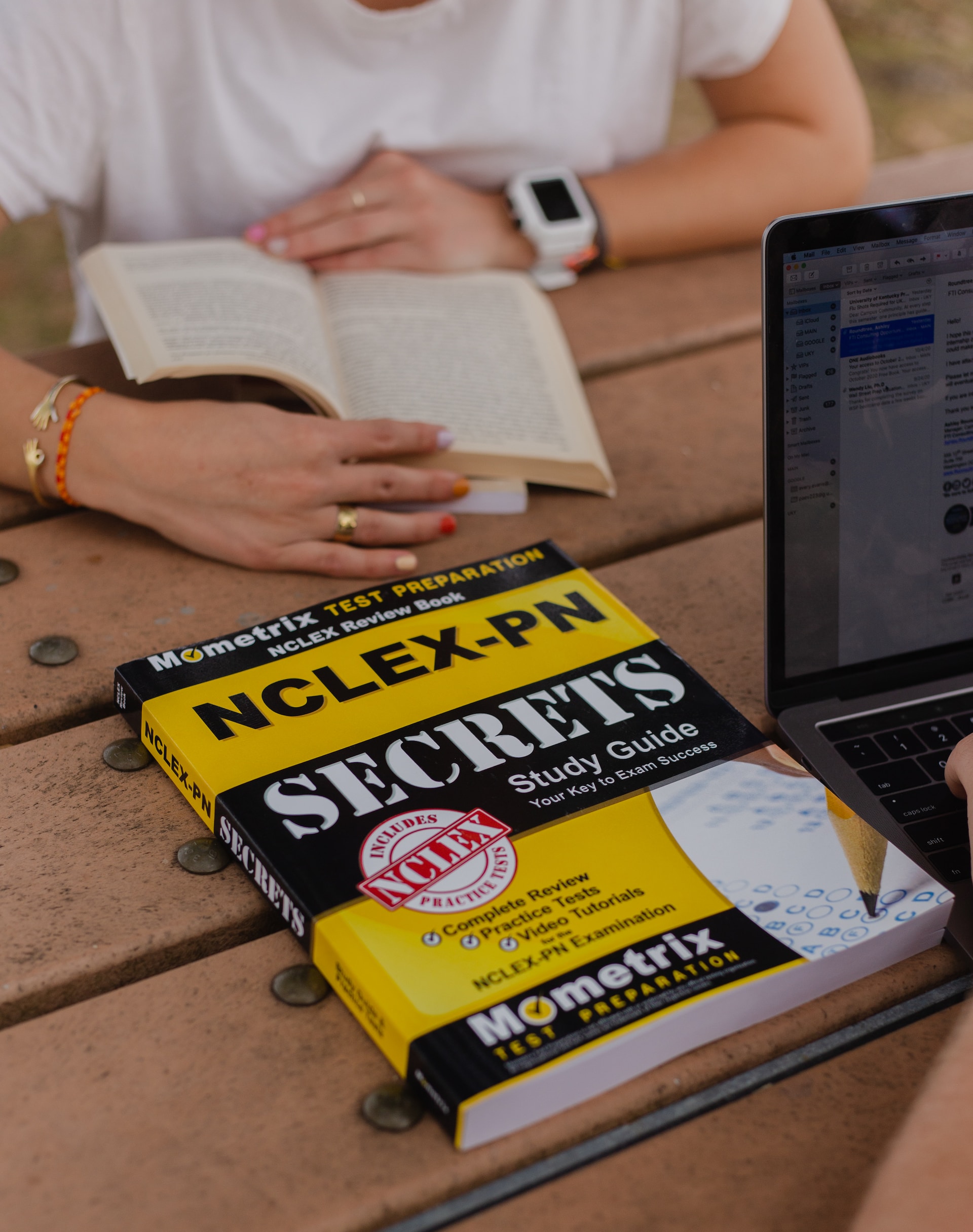 the image shows a book NCLEX-PN "Secrets Study Guide" and a female reading another book on the background 