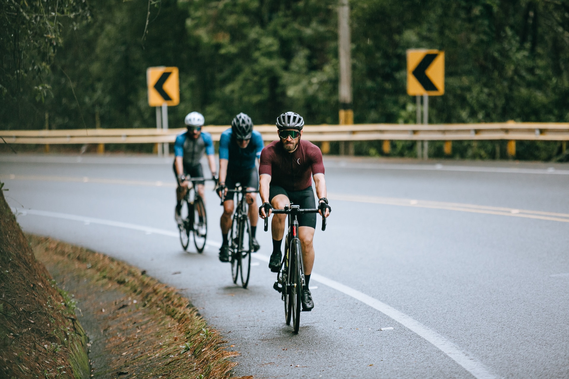 the image shows three athletes doing a cycling triathlon on the highway