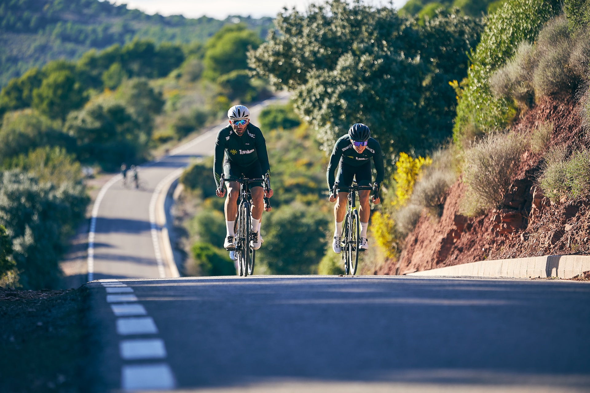 the image shows two professional athletes doing a cycling triathlon
