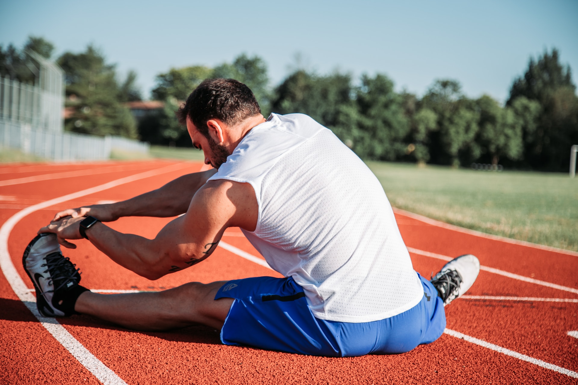 the image shows a male athlete doing stretching