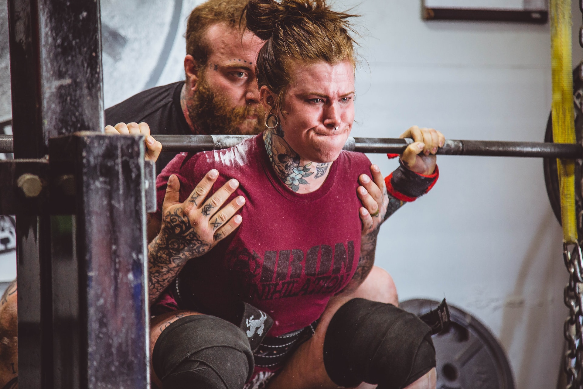 the image shows a woman lifting the barbell