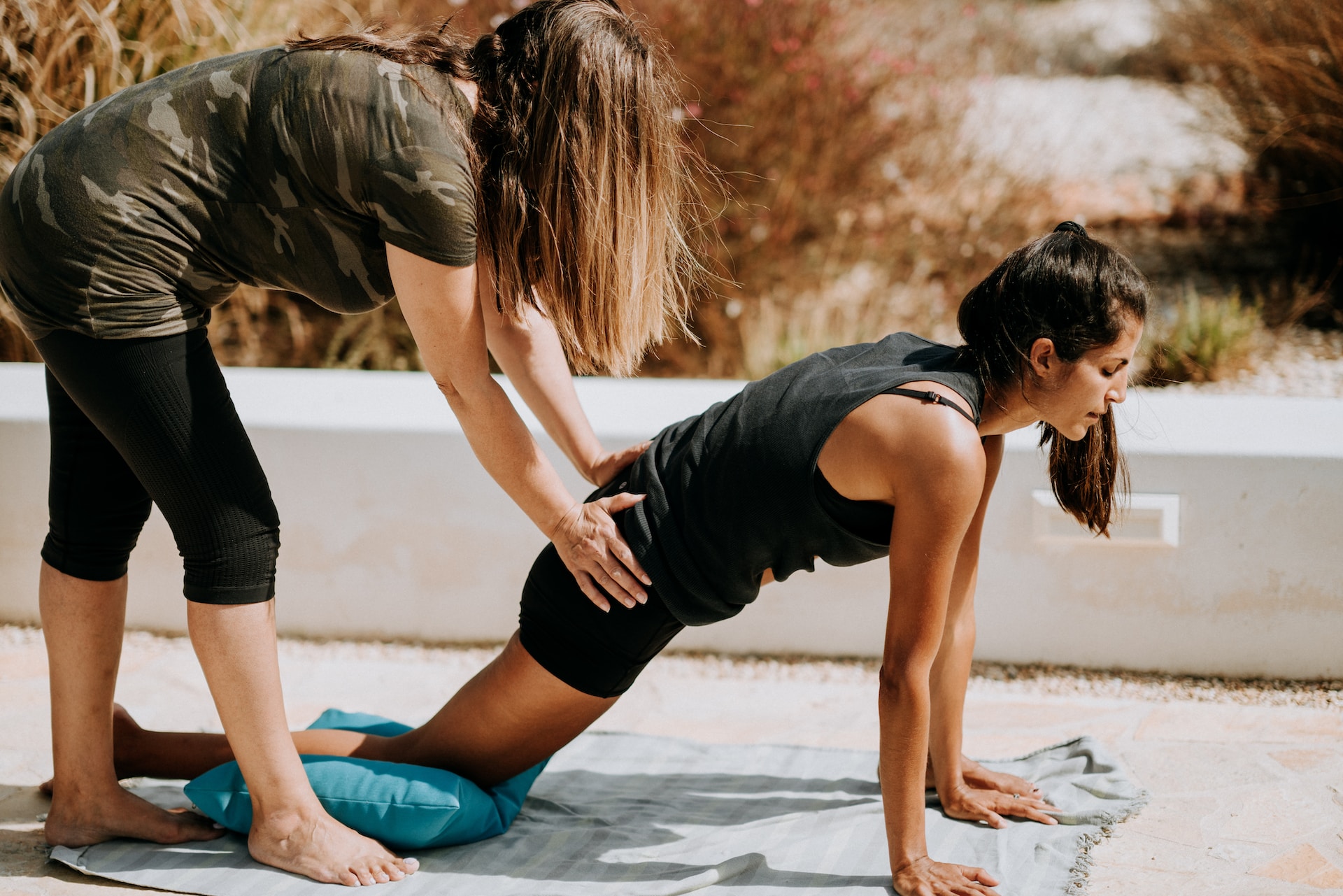 the image shows the coach and the sportwomen at the stretching training.