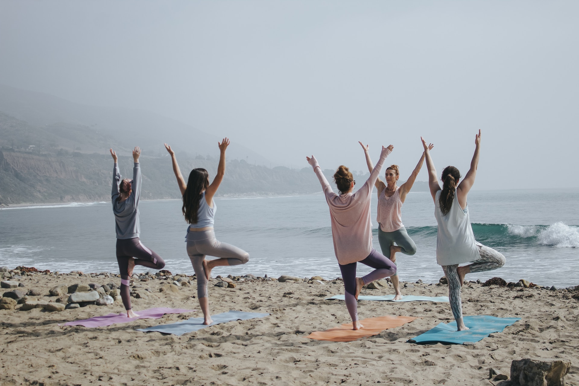 the image shows women at the yoga training at the beach