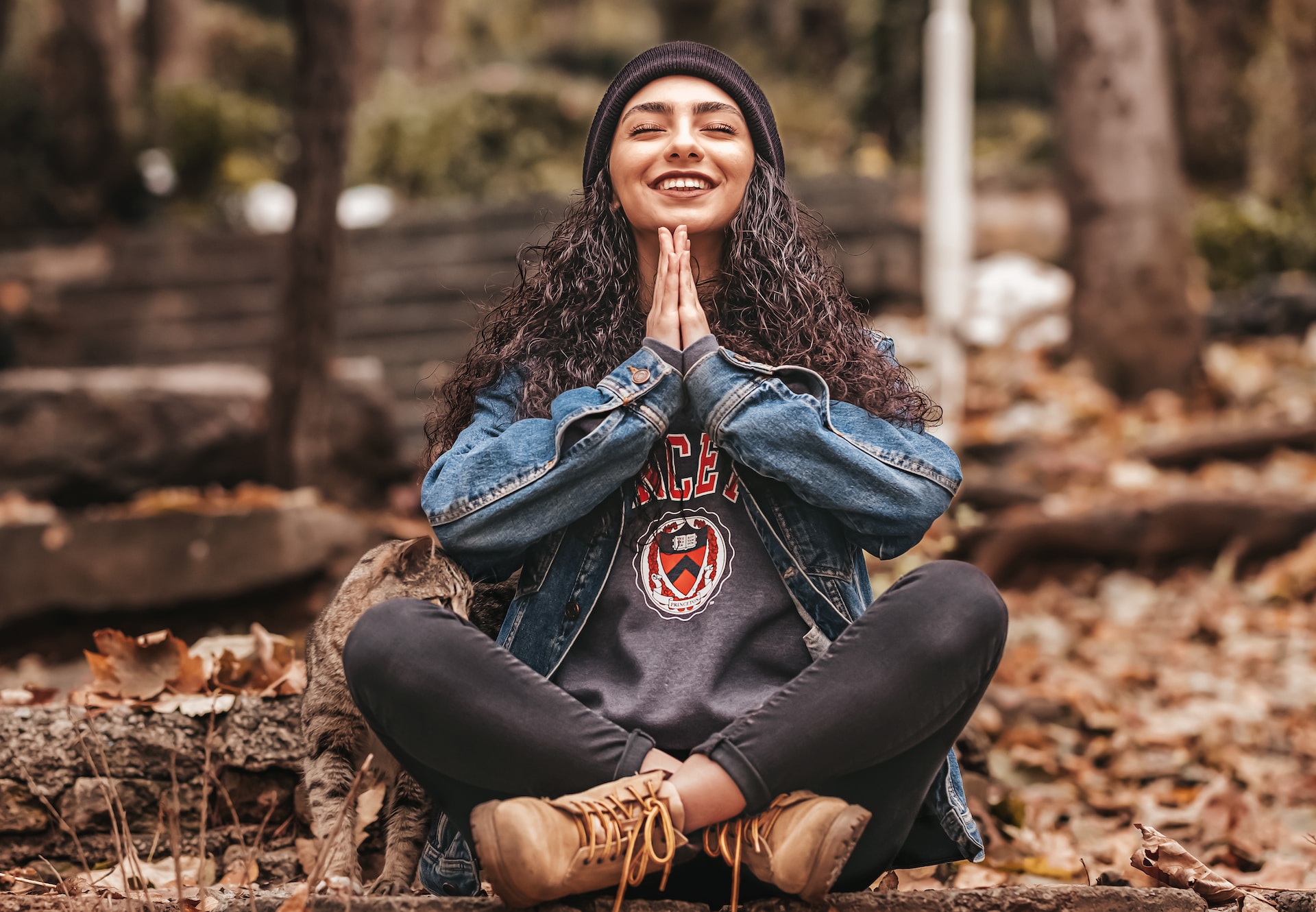 the image shows a woman sitting in a yoga pose in a forest