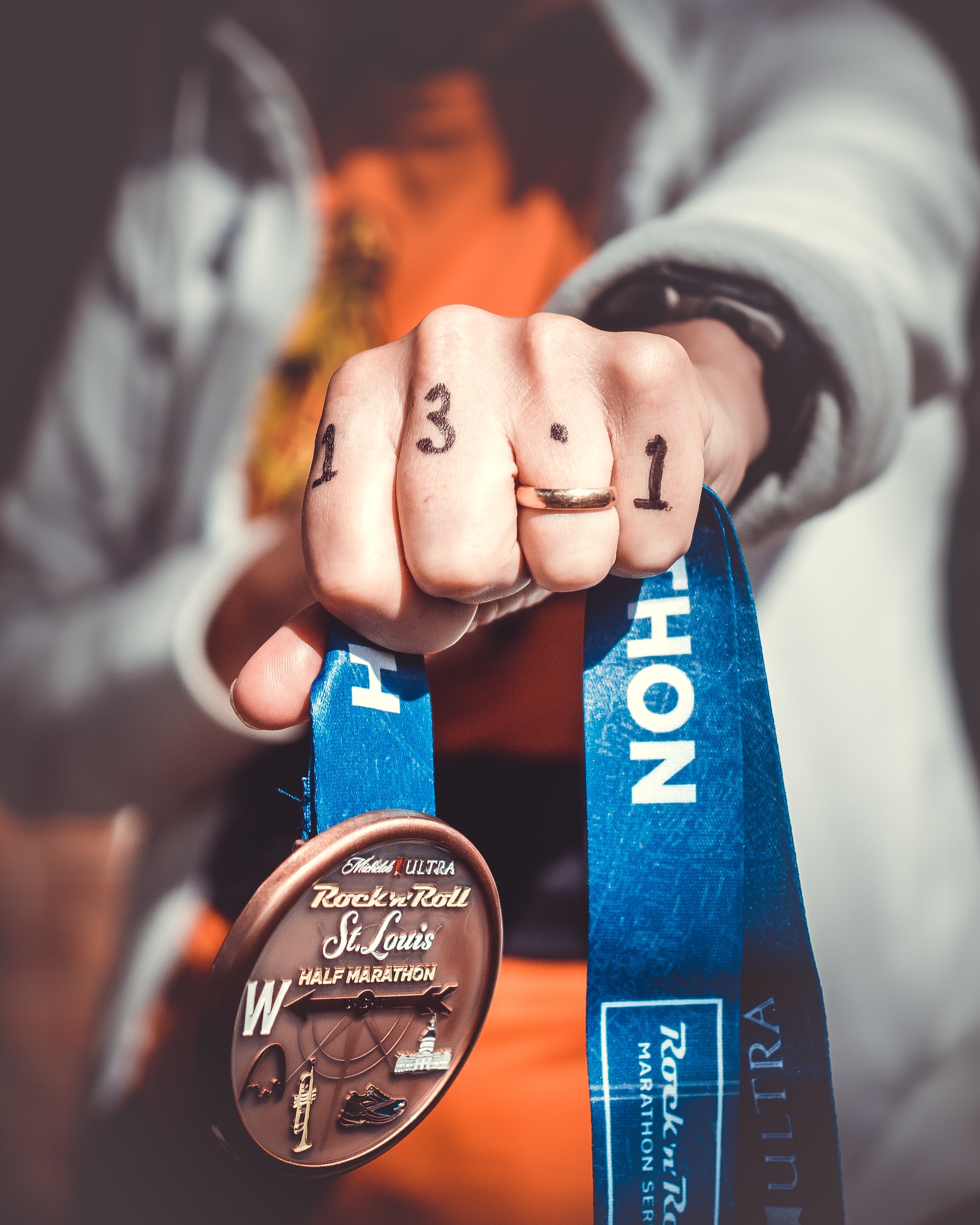 the image shows a hand holding a medal