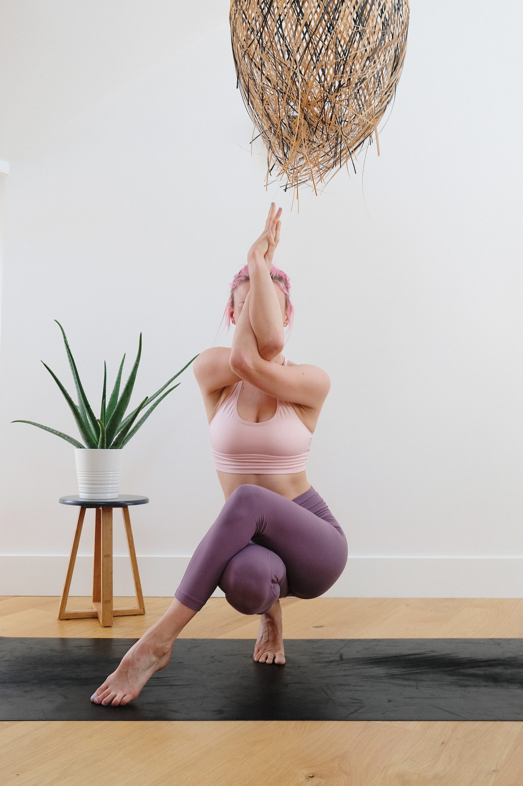 the image shows a woman doing a "cow face" yoga pose