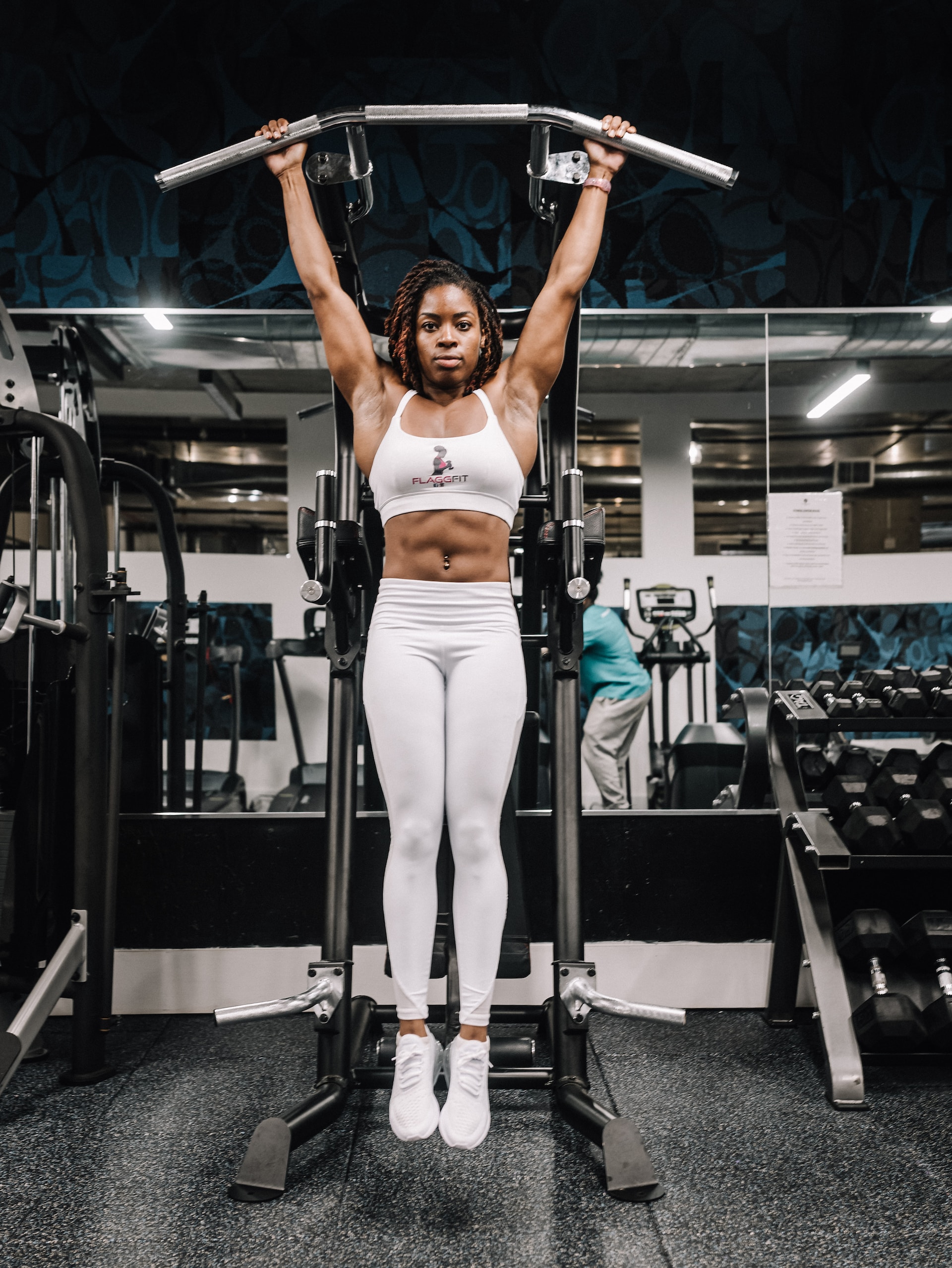 the image shows a woman pulling up at the gym